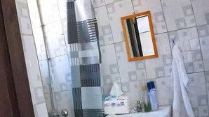 A bathroom with a shower, a sink, and a toilet. - Cosmos Haven Studio (Kisumu)