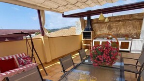 A sunlit outdoor dining area with a table set for two, featuring a pitcher of juice, glasses, and oranges. - Villa Las Tres J (Torrox Costa)