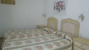 Una camera da letto con un letto, due comodini, una lampada a parete e un quadro floreale.