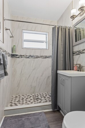 Ein Badezimmer mit Dusche, Toilette und Waschbecken.