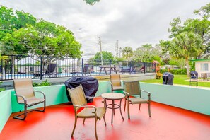 Relax in a tranquil outdoor space with a grill, seating area, and pool views.