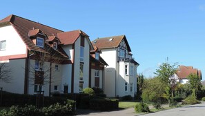 A row of residential buildings with pitched roofs and multiple windows.