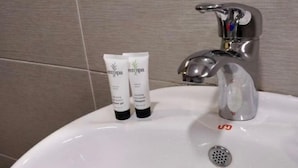 Un lavabo de bany amb dues tubets de loció i un robinet.