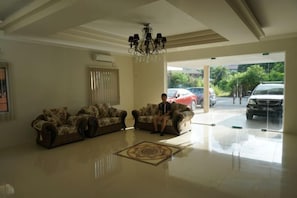 A spacious lobby with a chandelier, two sofas, and a large window. - Yew Hotel (Miri)