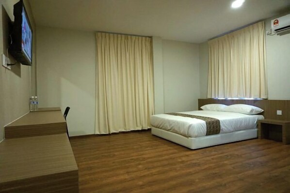 A hotel room with a bed, a desk, and a television. - Yew Hotel (Miri)