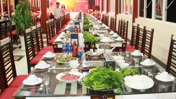 A long dining table set with various dishes and drinks, surrounded by wooden chairs. - ZO Star Tam Dao (Tam Dao)