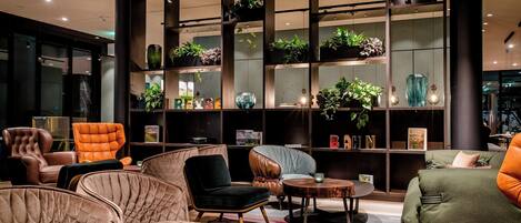 Un área de estar moderna con sofás y sillones de cuero, y una mesa de centro.