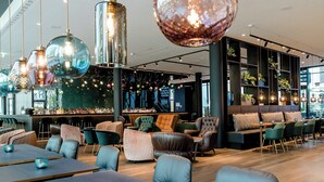 A modern interior with wooden flooring, leather seating, and hanging spherical light fixtures.