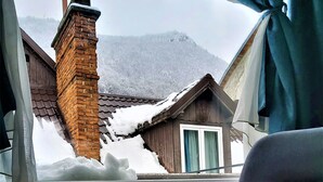Una habitación con vista a una montaña nevada y un edificio de madera.