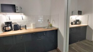 Una cocina moderna con microondas, cafetera, tostadora y fregadero.