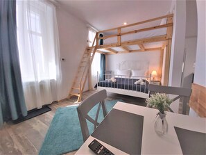 A room with a bunk bed, a desk with a computer, a chair, and a small table with a vase. - 92 Residence (Brasov)