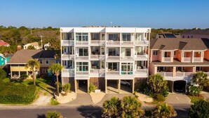 Un immeuble résidentiel à plusieurs étages, doté de balcons, d’un garage et d’une allée.