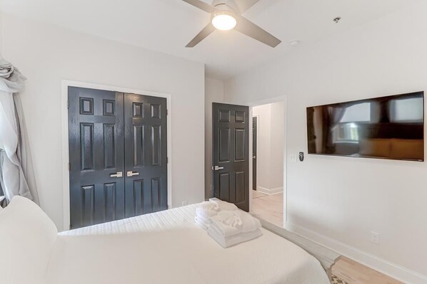 Relax in a stylish room with a made bed, ceiling fan, and flat-screen TV.