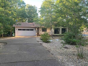 A residential property with a garage, driveway, and landscaped garden.