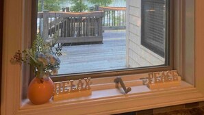 A window with a view of a wooden deck and a house.
