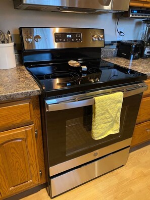A kitchen with a stainless steel stove, oven, and a digital control panel. - Lakefront living at its best - a guest favorite! (Hot Springs Village)
