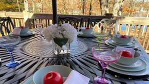 A table set for a meal with plates, bowls, and a vase of flowers.