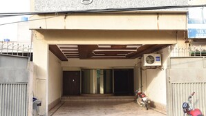 The entrance to Bright Hotel with a covered entrance, a motorcycle parked outside, and an air conditioning unit on the wall. - Bright Hotel (Lahore)