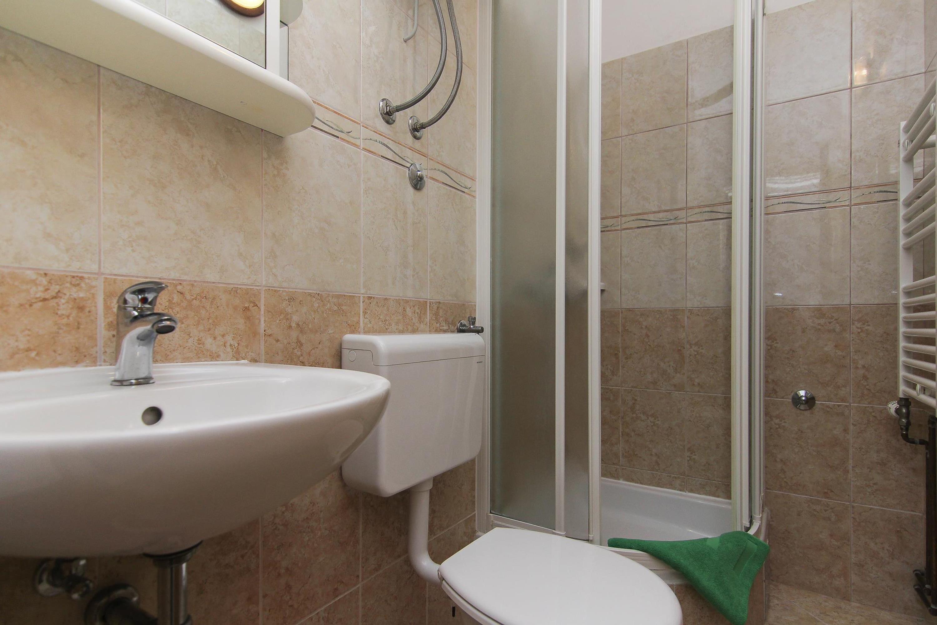Une salle de bain équipée d’un lavabo, de toilettes et d’une douche à parois en verre.