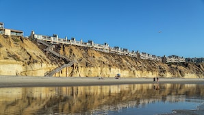 Un quartier résidentiel situé sur la côte, avec une colline et une plage.