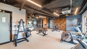 A gym with various exercise equipment, including treadmills, a stationary bike, and weightlifting stations. - Apartamenty Sun & Snow Riverside Sienna (Gdansk)