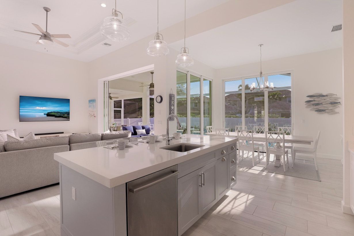 A modern kitchen with a central island, stainless steel appliances, and pendant lighting.
