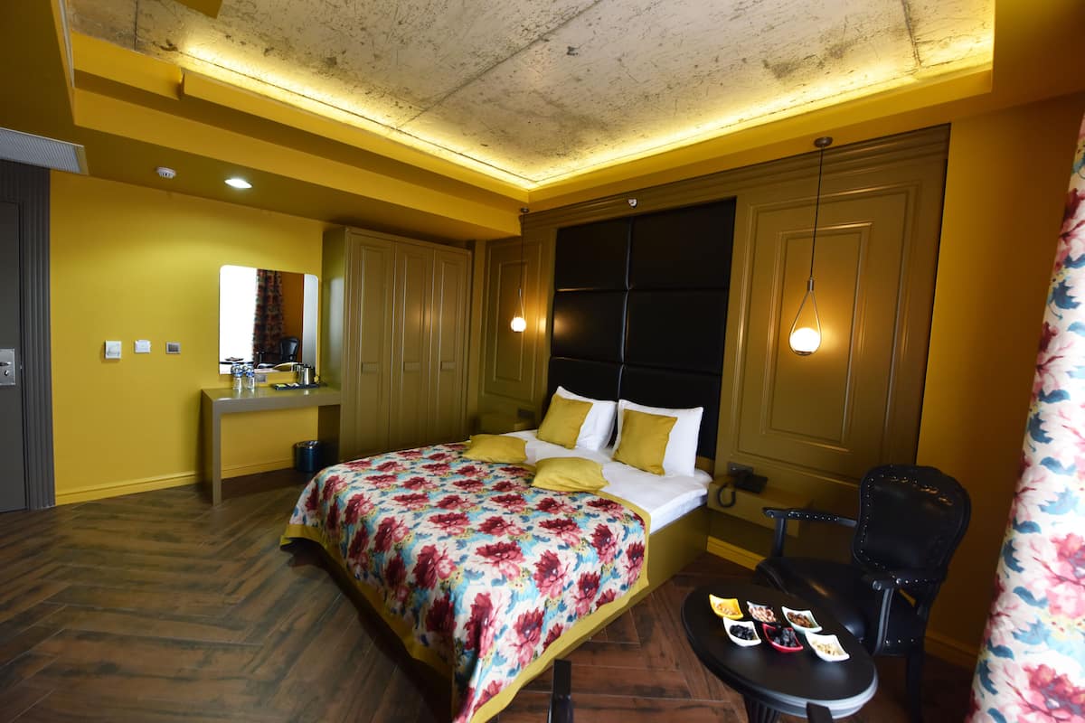 Una habitación de hotel con cama, mesita de noche y una silla.