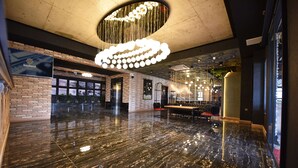 A spacious lobby with a polished marble floor, a large chandelier, and a seating area with tables and chairs. - Bayberd Hotel (Bayburt)