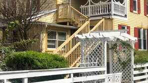 A two-story house with a balcony, a wooden fence, and a small garden area. - Private 3 room Queen Suite w/Kitchenette  (Port Deposit)