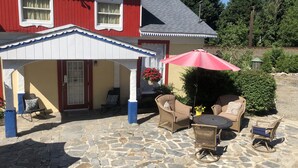 A house with a red and white exterior, a covered porch with wicker furniture, and a stone patio. - Private 3 room Queen Suite w/Kitchenette  (Port Deposit)