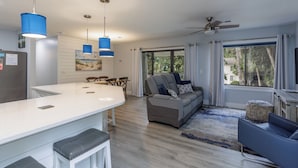A modern kitchen with a white countertop, blue pendant lights, and a ceiling fan. - 44 Forest Gardens: Luxurious Remodeled Villa, Walk to Beach, Pool, Free Bikes (Hilton Head Island)