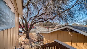 A wooden deck with a staircase leading to a covered area. - Binky's Nest 1 Bedroom Home by RedAwning (Fredericksburg)