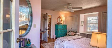 A bedroom with a bed, dresser, and a mirror.
