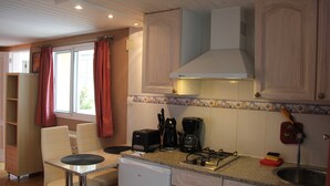 Een keuken met een eethoek, een vaatwasser, een koffiezetapparaat en een spoelbak.