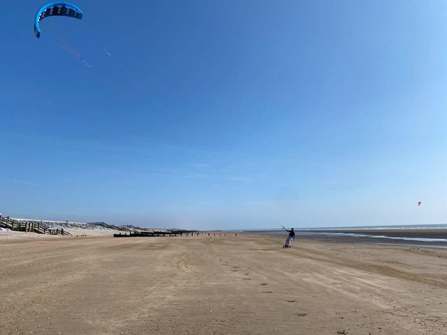 A wide, open beach with a clear sky.