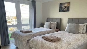 Una habitación de hotel con dos camas, un ventanal grande y un cuadro en la pared.