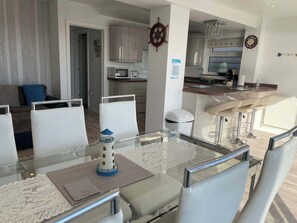 A modern kitchen with a central island, white cabinetry, and a microwave.