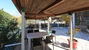 Un área de patio al aire libre con una pérgola de madera, una mesa y sillas.