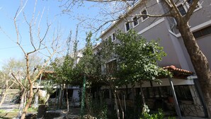 Un edificio con varias ventanas, un árbol en primer plano y un cielo despejado.