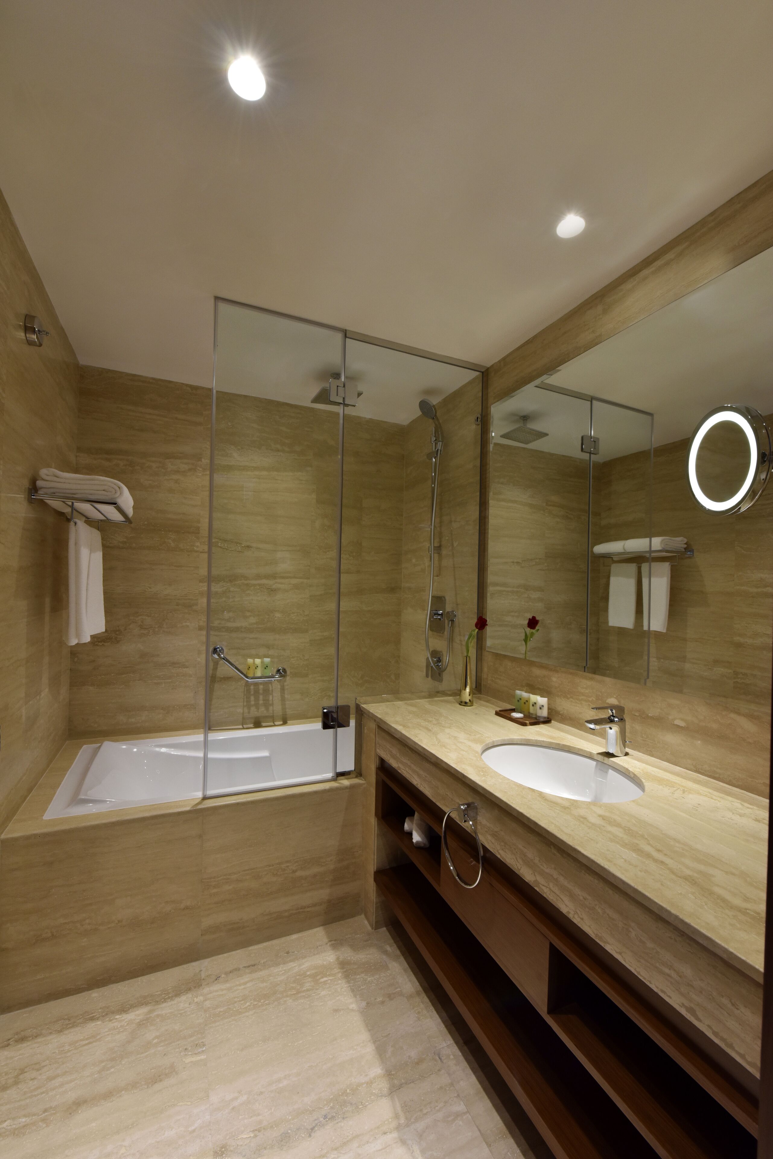 Un baño moderno con un espejo grande, una bañera y un tocador con lavabo.