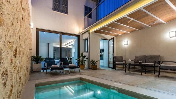 An indoor swimming pool area with a seating area and a view into the adjacent room. - Casa Bugera, Beautiful restored house in Pollensa (Pollença)