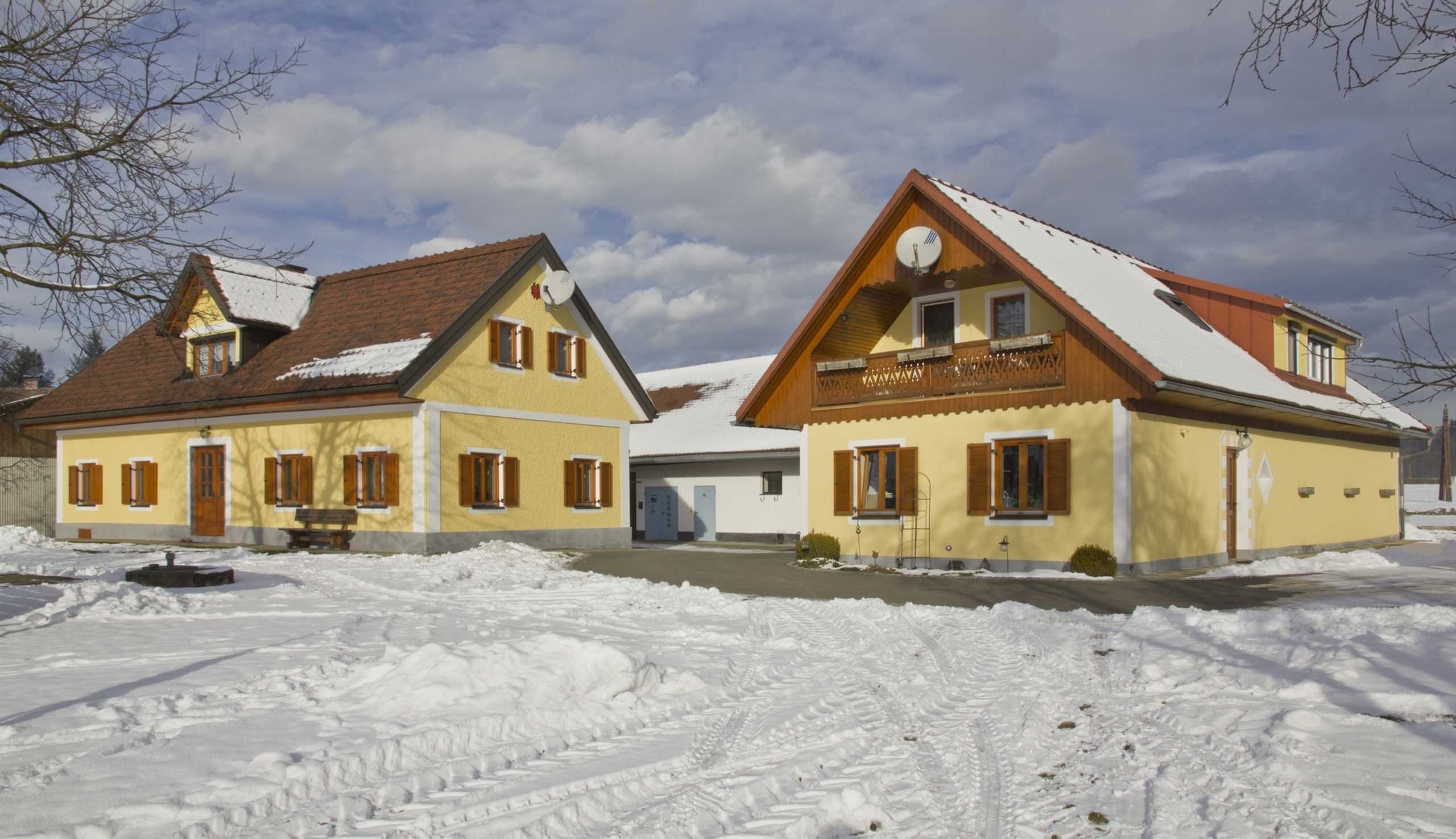A two-story building with a snow-covered roof and a visible satellite dish.
