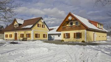 A two-story building with a snow-covered roof and a visible satellite dish.