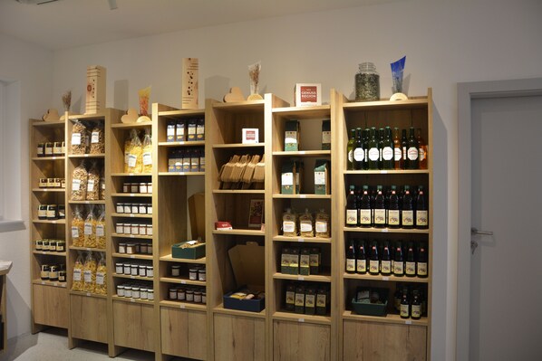 A series of wooden shelves stocked with various food items and bottles.