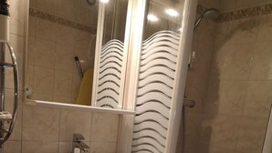 A bathroom with a white sink, mirror, and shower.