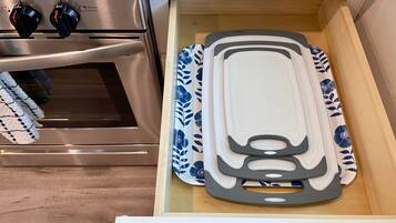 A kitchen drawer with a cutting board and a spatula.