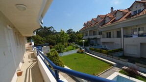 Ein Wohngebäude mit Balkon, gepflegtem Rasen und blauem Himmel.