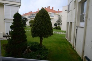 Stroll through the serene courtyard surrounded by mature trees and a beautifully maintained lawn.