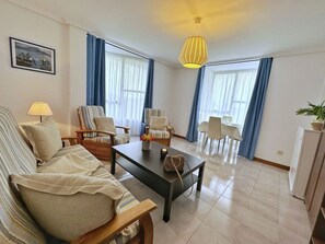 Relax in this inviting living space with a sofa, coffee table, and dining area.