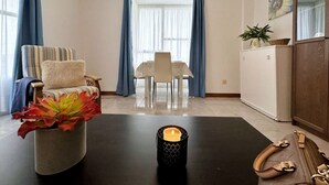 A modern living room with a dining area, featuring a sofa, a dining table, and a cabinet.